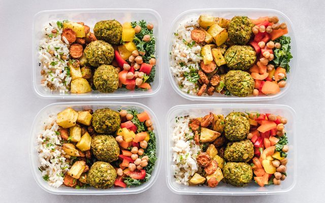 Quatre contenants de batch cooking alignés, chacun avec riz, légumes rôtis, falafels et crudités