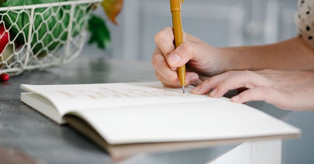 Menu de la semaine écrit à la main dans un carnet, à côté d’un panier de légumes frais